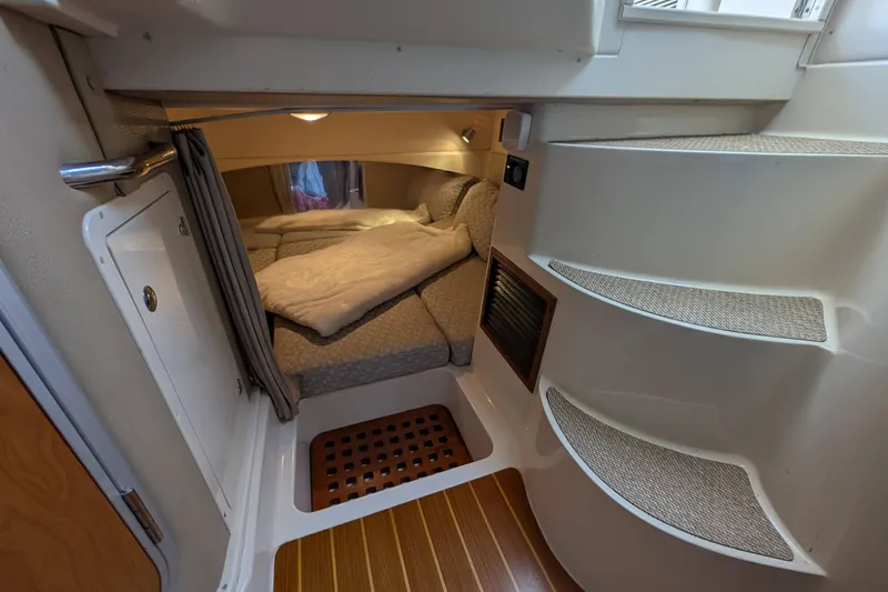 Slide: The Image of 2010 Grady-White Express 330 cabin interior with cozy bed and wooden flooring. - 25
