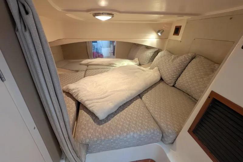 Slide: The Image of 2010 Grady-White Express 330 cabin interior with cozy bedding and cushions. - 26