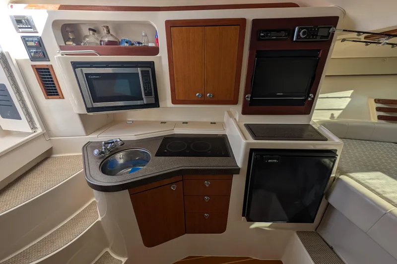 Slide: The Image of 2010 Grady-White Express 330 boat interior with kitchenette, microwave, sink, and mini fridge. - 40
