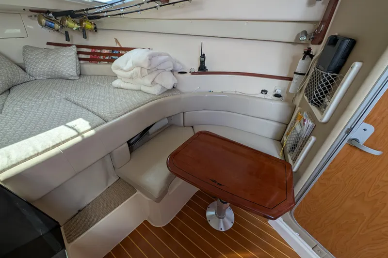 Slide: The Image of 2010 Grady-White Express 330 cabin interior with seating, table, and fishing rods. - 41