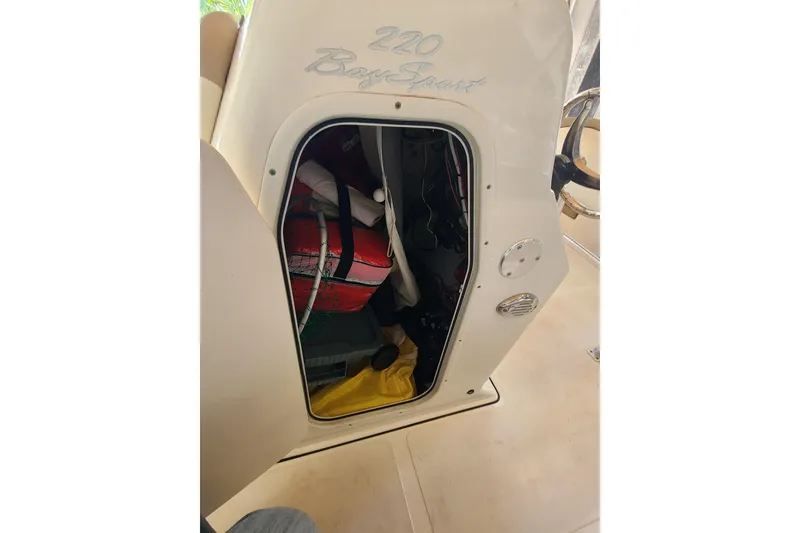 Slide: The Image of 2015 Pioneer 220 Bay Sport boat storage compartment with life jackets and equipment. - 21