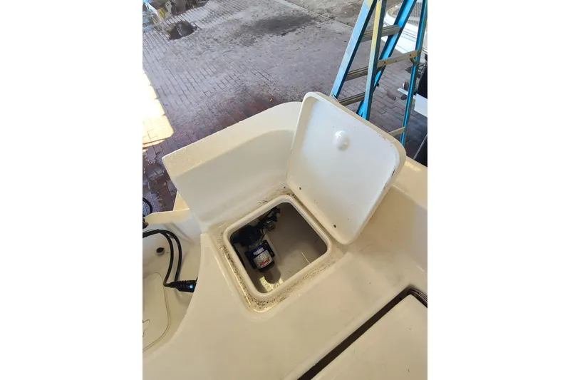 Slide: The Image of Open storage compartment on 2015 Pioneer 220 Bay Sport boat, showing internal components. - 26