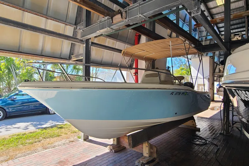 Slide: The Image of 2015 Pioneer 220 Bay Sport boat in storage, light blue hull, under a metal roof. - 3