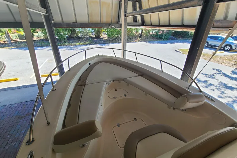 Slide: The Image of 2015 Pioneer 220 Bay Sport boat interior under shelter, featuring cushioned seating. - 6