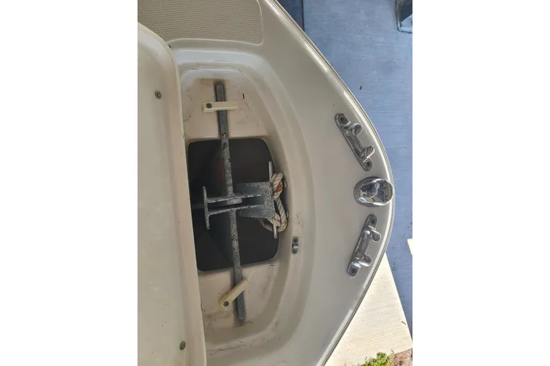 Slide: The Image of 2015 Pioneer 220 Bay Sport boat anchor compartment with cleats and rope. - 7