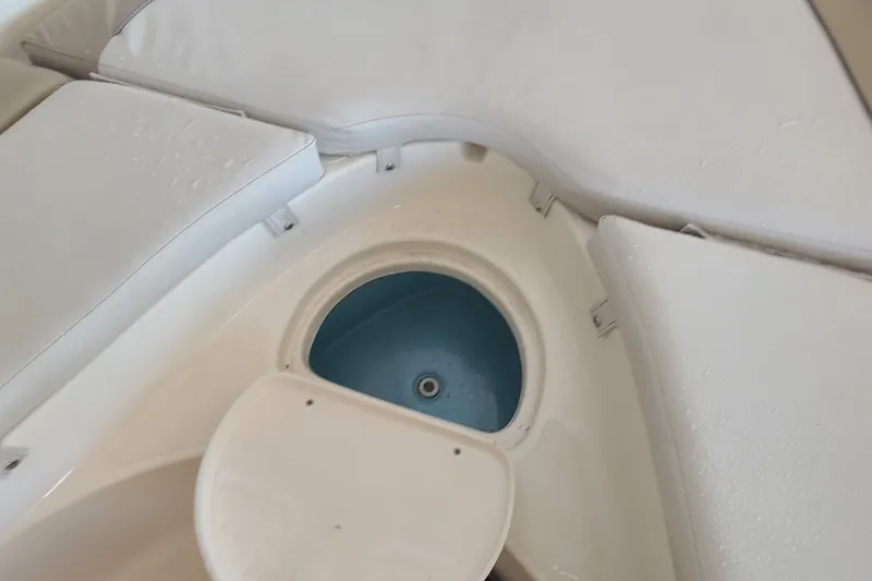 Slide: The Image of 2015 Pioneer 220 Bay Sport boat interior with storage compartment and cushioned seating. - 8