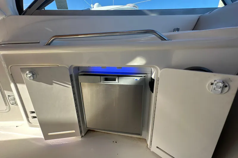 Slide: The Image of 2000 Sea Ray 340 Sundancer boat interior with open cabinet and mini fridge. - 20