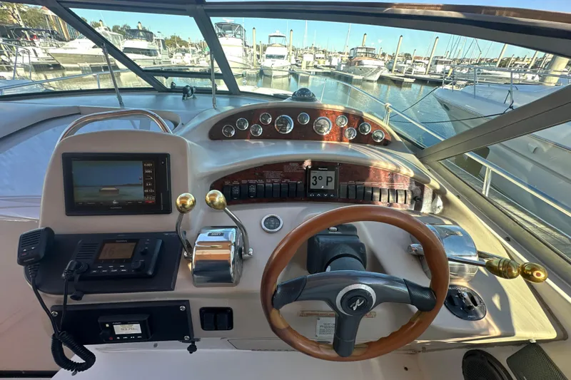 Slide: The Image of Cockpit view of 2000 Sea Ray 340 Sundancer yacht with steering wheel and navigation instruments. - 26