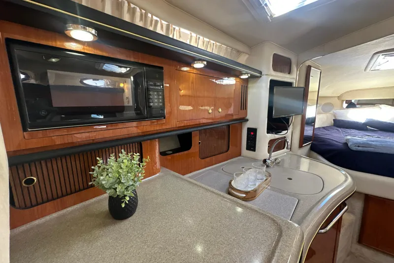 Slide: The Image of Luxurious interior of 2000 Sea Ray 340 Sundancer yacht with kitchenette and cozy sleeping area. - 31