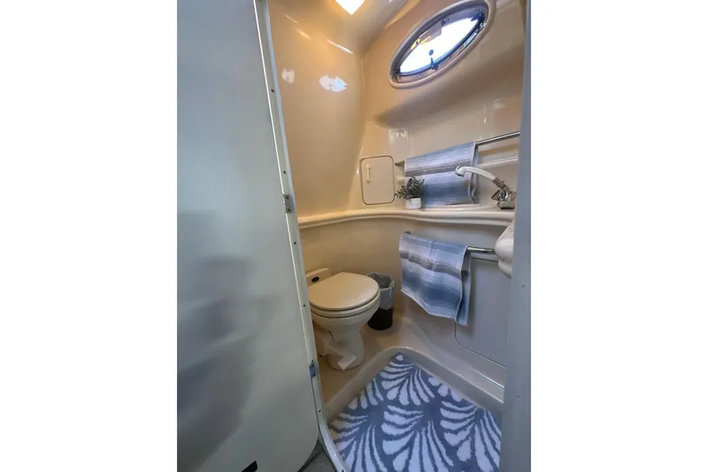 Slide: The Image of 2000 Sea Ray 340 Sundancer bathroom with toilet, sink, and nautical decor. - 43