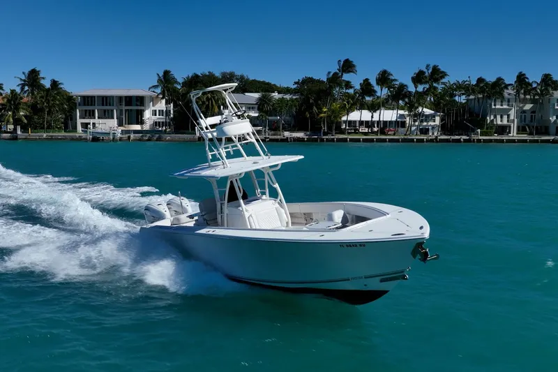 Slide: The Image of 2019 Jupiter 38 HFS boat cruising on turquoise water near palm-lined shore. - 10