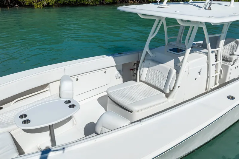 Slide: The Image of 2019 Jupiter 38 HFS boat interior with white seating and table on turquoise water. - 14