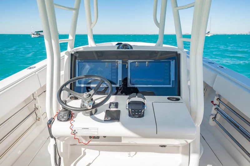 Slide: The Image of 2019 Jupiter 38 HFS boat cockpit with steering wheel and navigation screens on open water. - 33