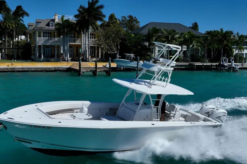 Slide: The Image of 2019 Jupiter 38 HFS boat cruising on turquoise water near luxury waterfront homes. - 5