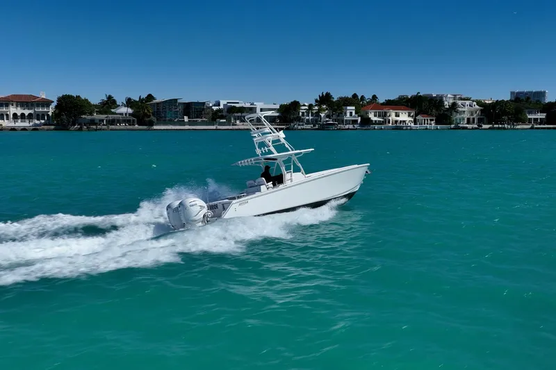 Slide: The Image of 2019 Jupiter 38 HFS boat cruising on turquoise water near luxury waterfront homes. - 52