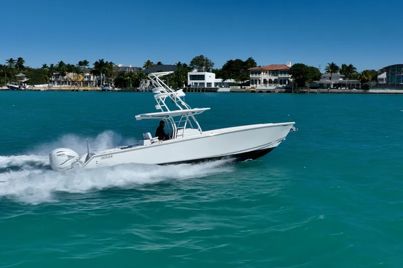 Slide: The Image of 2019 Jupiter 38 HFS boat cruising on turquoise water near luxury waterfront homes. - 6