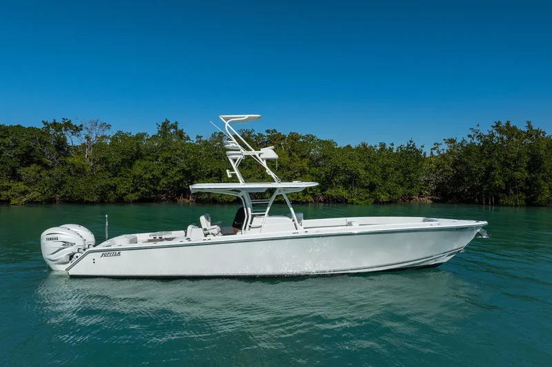 Slide: The Image of 2019 Jupiter 38 HFS boat on calm water with lush green background. - 61