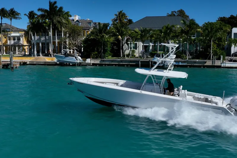Slide: The Image of 2019 Jupiter 38 HFS boat cruising in turquoise waters near luxury waterfront homes. - 69
