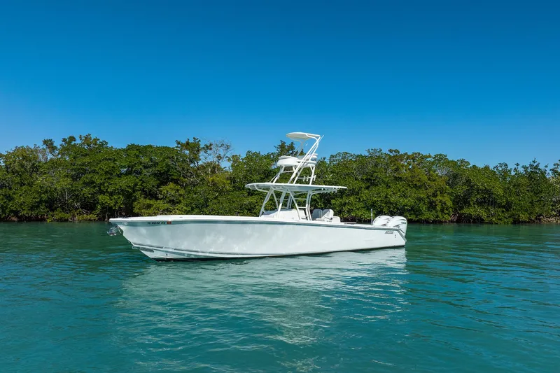 Slide: The Image of 2019 Jupiter 38 HFS boat on calm water with lush green trees in the background. - 76