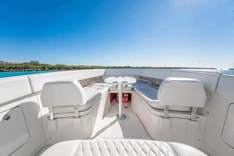 Slide: The Image of 2019 Jupiter 38 HFS boat interior with seating and table, under clear blue sky. - 80