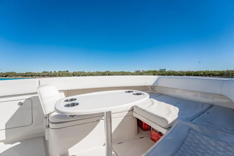 Slide: The Image of 2019 Jupiter 38 HFS boat interior with seating and table under clear blue sky. - 81
