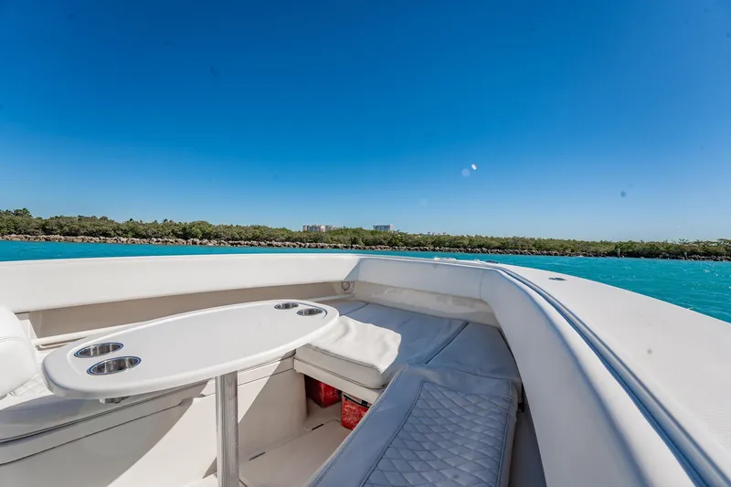 Slide: The Image of 2019 Jupiter 38 HFS boat interior with seating and table, cruising on clear blue water. - 82