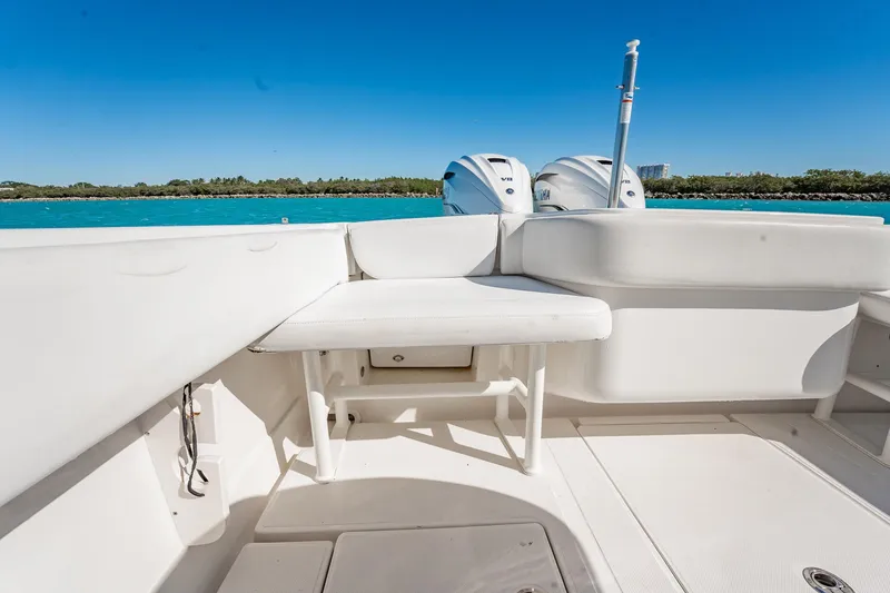 Slide: The Image of 2019 Jupiter 38 HFS boat interior with seating and dual engines, under clear blue sky. - 89