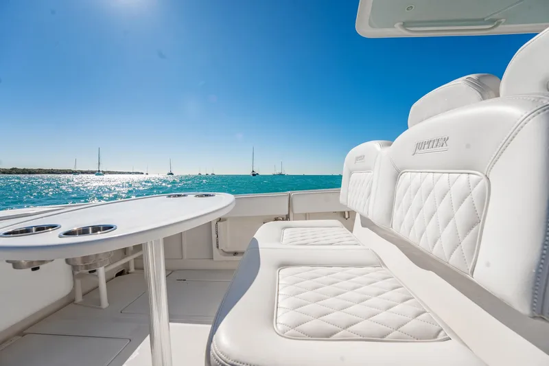 Slide: The Image of 2019 Jupiter 38 HFS boat interior with white seating, ocean view, and clear blue sky. - 95
