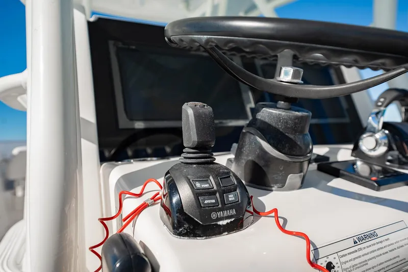 Slide: The Image of Close-up of 2019 Jupiter 38 HFS boat controls with Yamaha joystick and steering wheel. - 96