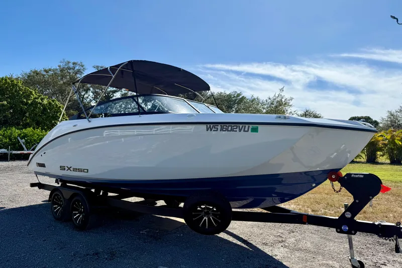 Slide: The Image of 2024 Yamaha SX 250 boat on trailer, parked outdoors under clear blue sky. - 2