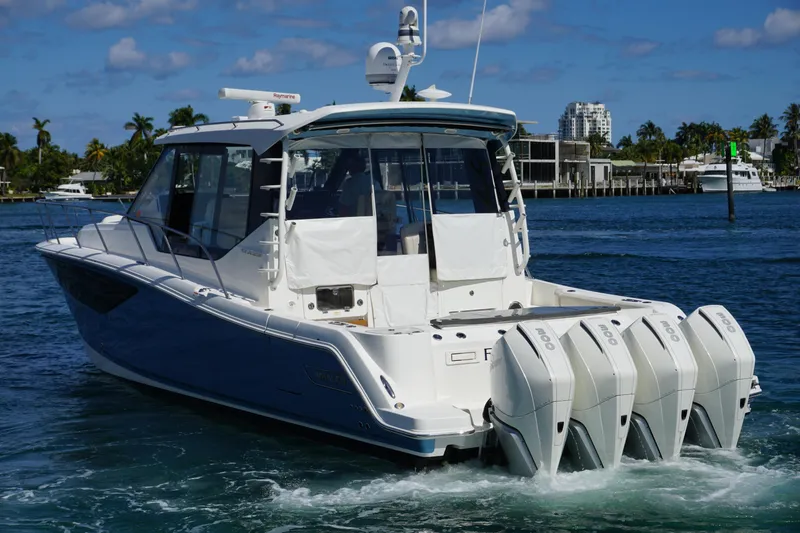 Slide: The Image of 2021 Boston Whaler 405 Conquest boat with four engines cruising on a sunny day. - 11