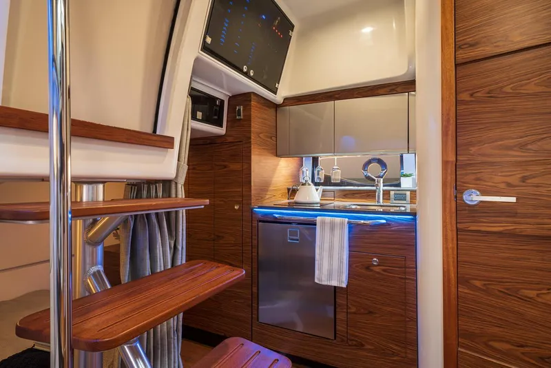 Slide: The Image of Manufacturer Provided Image: Interior of 2021 Boston Whaler 405 Conquest yacht kitchen area with wooden cabinetry. - 28