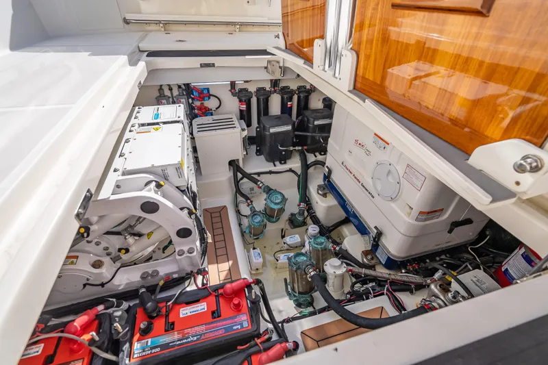 Slide: The Image of Engine compartment of 2021 Boston Whaler 405 Conquest, showcasing batteries and mechanical components. - 59