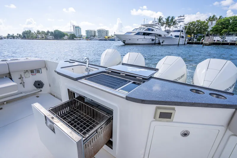 Slide: The Image of Boston Whaler 405 Conquest 2021 boat deck with grill and storage, docked by waterfront. - 63