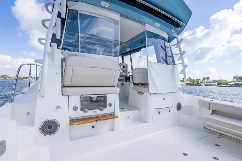 Slide: The Image of 2021 Boston Whaler 405 Conquest boat interior with seating and helm, on a sunny day. - 65