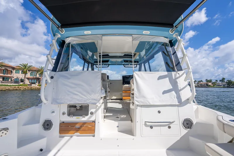 Slide: The Image of 2021 Boston Whaler 405 Conquest boat, rear view, docked near waterfront homes. - 69