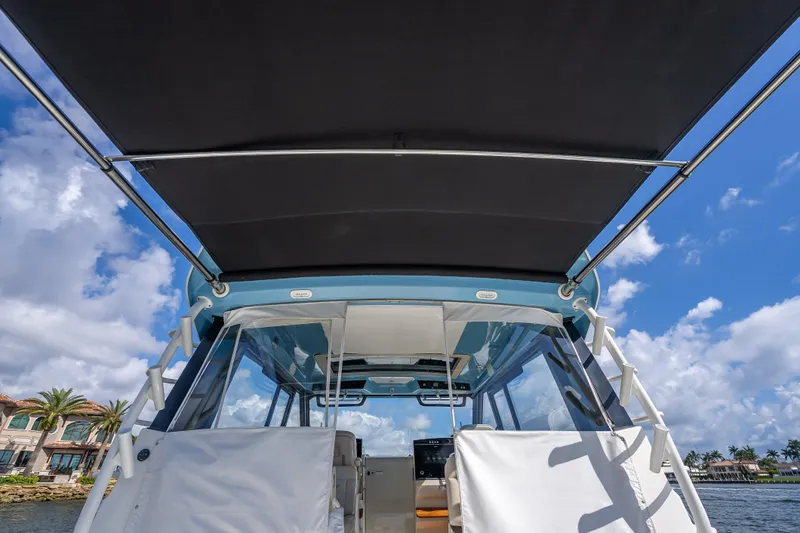 Slide: The Image of Boston Whaler 405 Conquest 2021 boat with canopy, under a clear blue sky. - 70