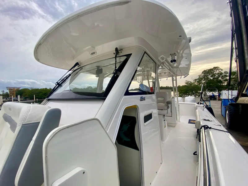 Slide: The Image of 2016 Everglades 435 Center Console boat docked, showcasing sleek design and spacious deck. - 19
