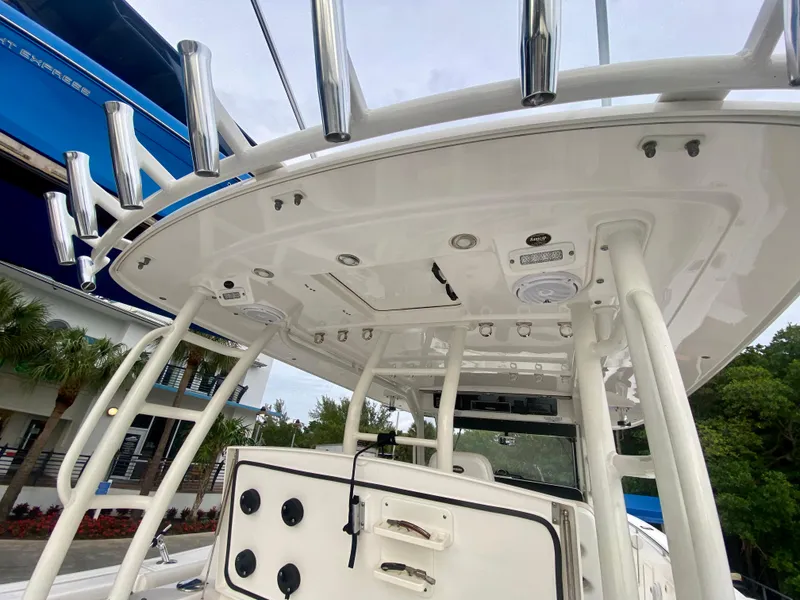 Slide: The Image of 2016 Everglades 435 Center Console boat, featuring a sleek white helm and rod holders. - 8