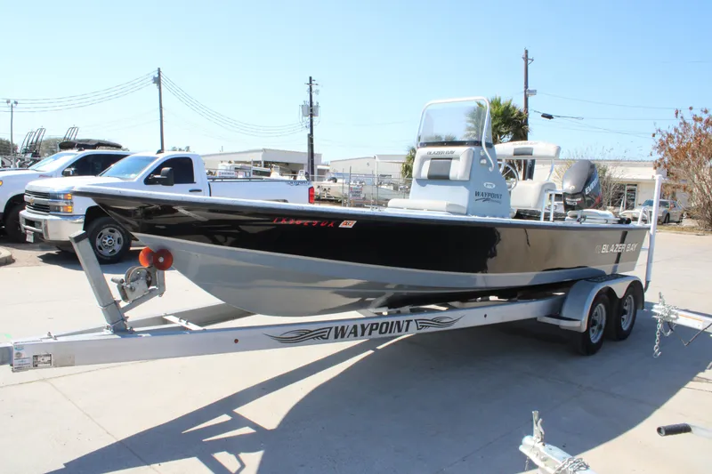 Slide: The Image of 2017 Blazer Bay 2170 boat on trailer, parked outdoors in a lot. - 2