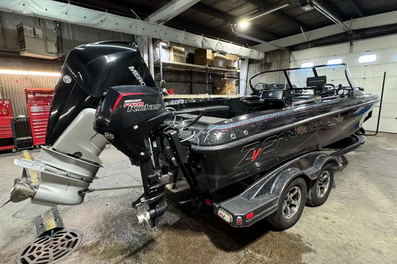 Slide: The Image of 2020 Nitro ZV21 boat with Mercury Pro Kicker engine in a garage setting. - 3