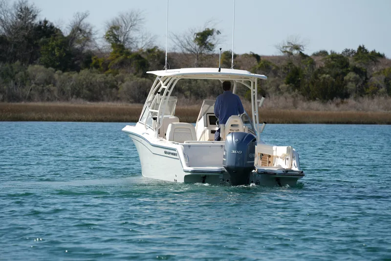 Slide: The Image of 2020 Grady-White Freedom 235 boat cruising on a serene lake. - 11
