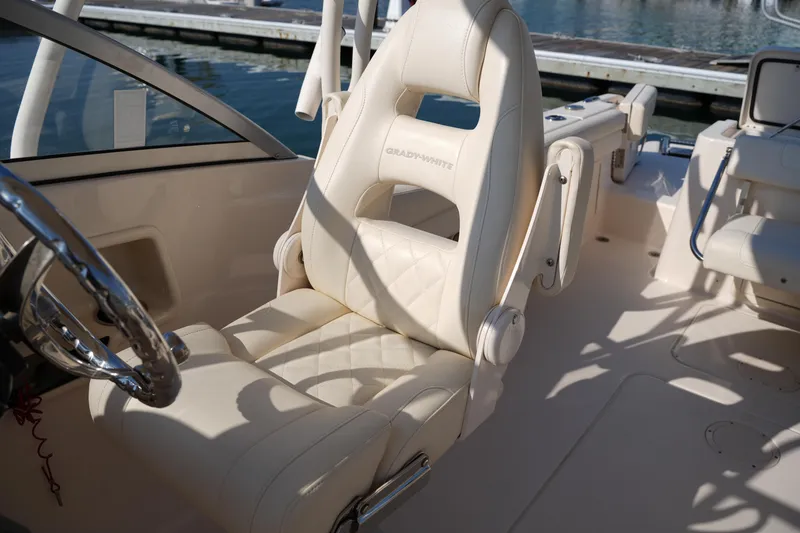 Slide: The Image of 2020 Grady-White Freedom 235 boat interior with luxurious seating and steering wheel. - 21