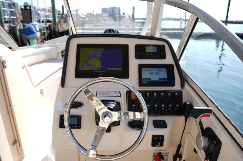 Slide: The Image of Helm of 2020 Grady-White Freedom 235 boat with navigation screens and controls. - 23