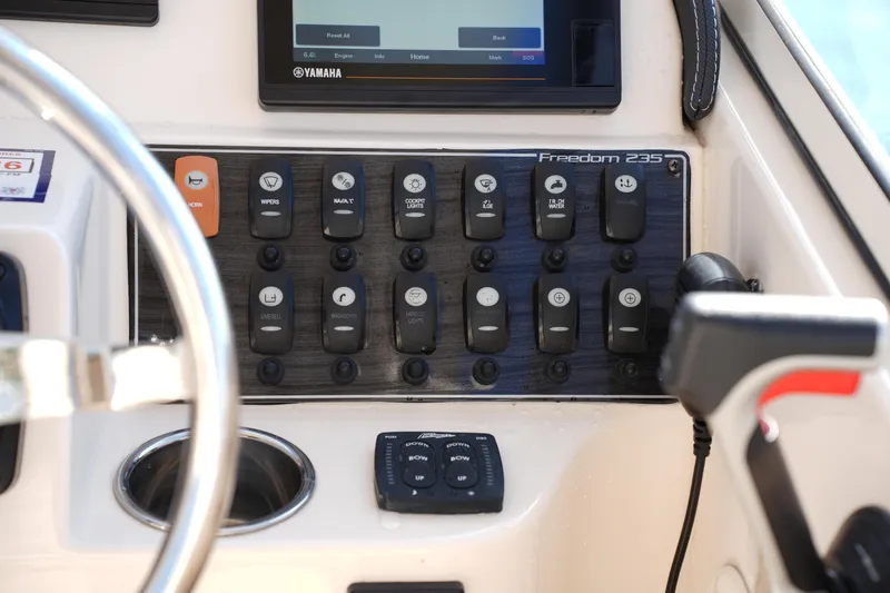 Slide: The Image of Control panel of 2020 Grady-White Freedom 235 boat with switches and Yamaha display. - 26