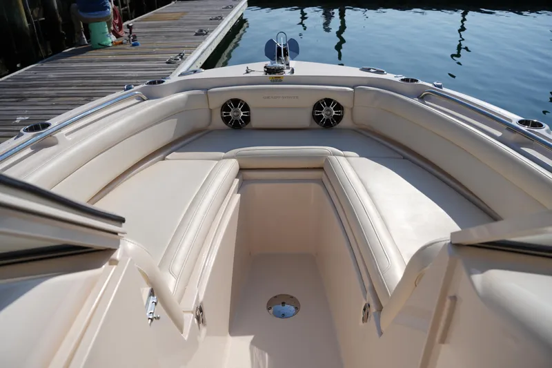 Slide: The Image of 2020 Grady-White Freedom 235 boat interior with cushioned seating and dockside view. - 29