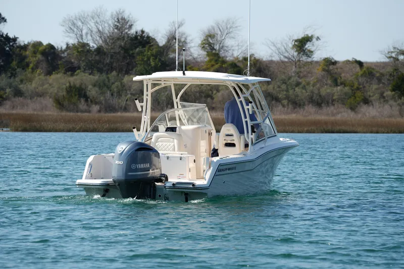 Slide: The Image of 2020 Grady-White Freedom 235 boat cruising on a serene lake with Yamaha engine. - 9