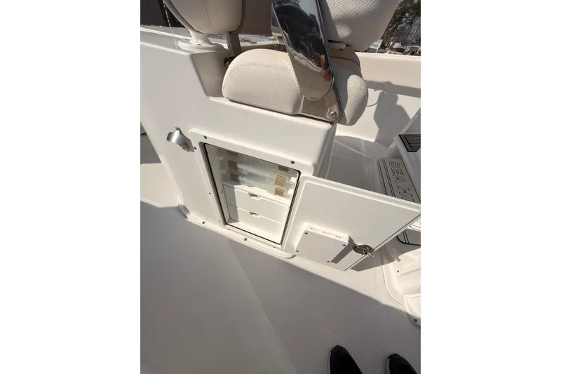 Slide: The Image of 2023 Sea Hunt Gamefish 25 boat interior with cushioned seating and steering console. - 12