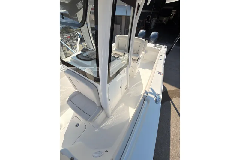 Slide: The Image of 2023 Sea Hunt Gamefish 25 boat interior with seating and storage, docked outdoors. - 15