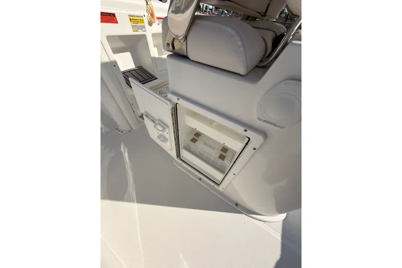 Slide: The Image of 2023 Sea Hunt Gamefish 25 helm with steering wheel, dual displays, and control panel. - 26